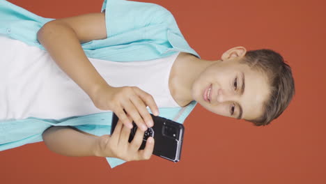 Vertical-video-of-The-boy-who-likes-the-new-app.-Phone-app.